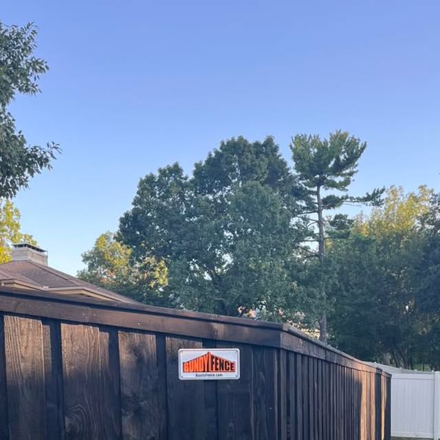 Pre-stained black board-on-board privacy fence with top cap and trim