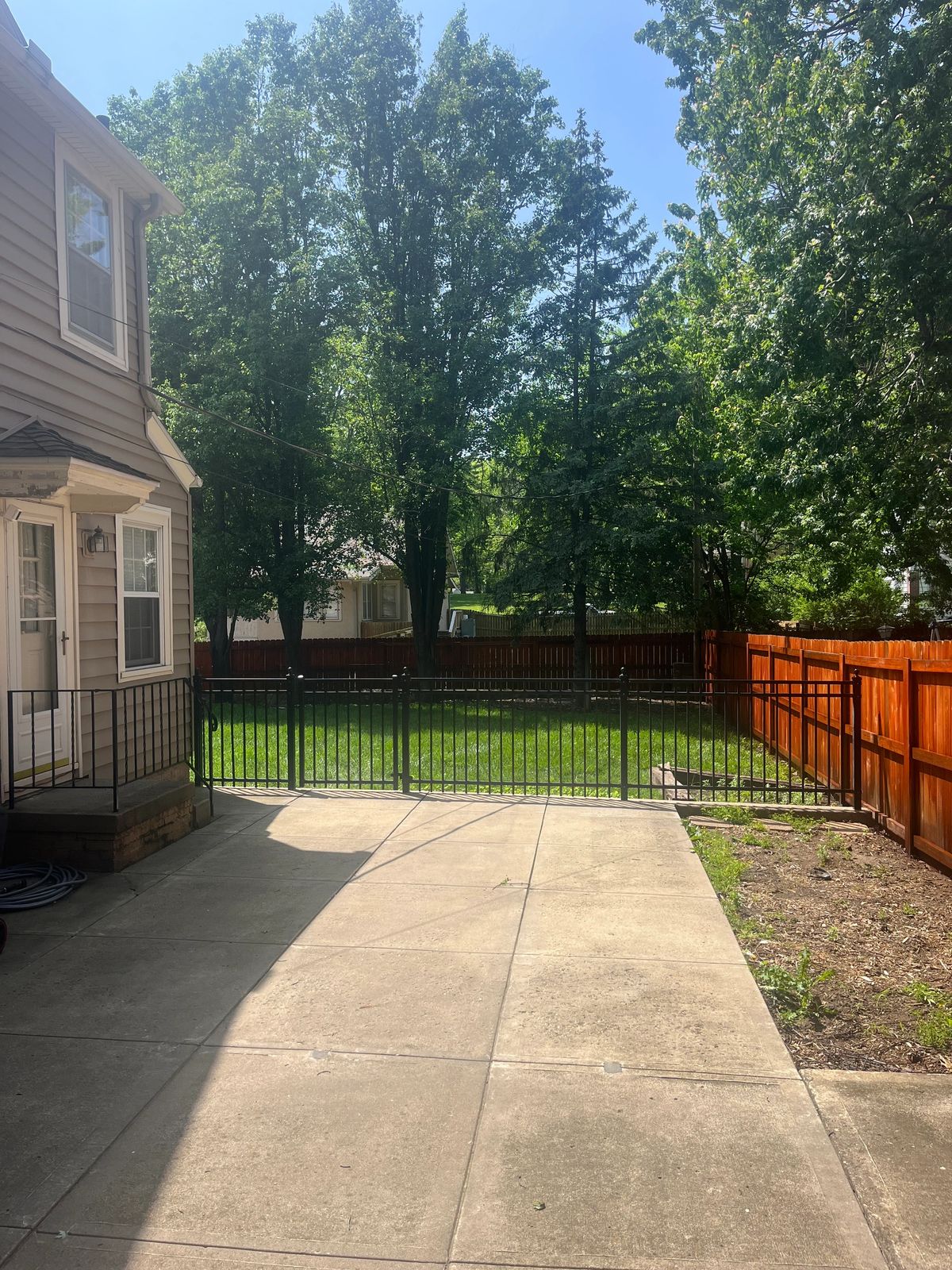 Black ornamental metal driveway fence and gate